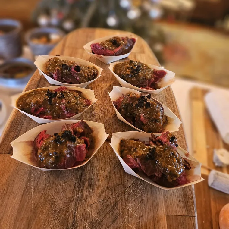 Coquilles farcies et gratinées, dressées sur une planche.
